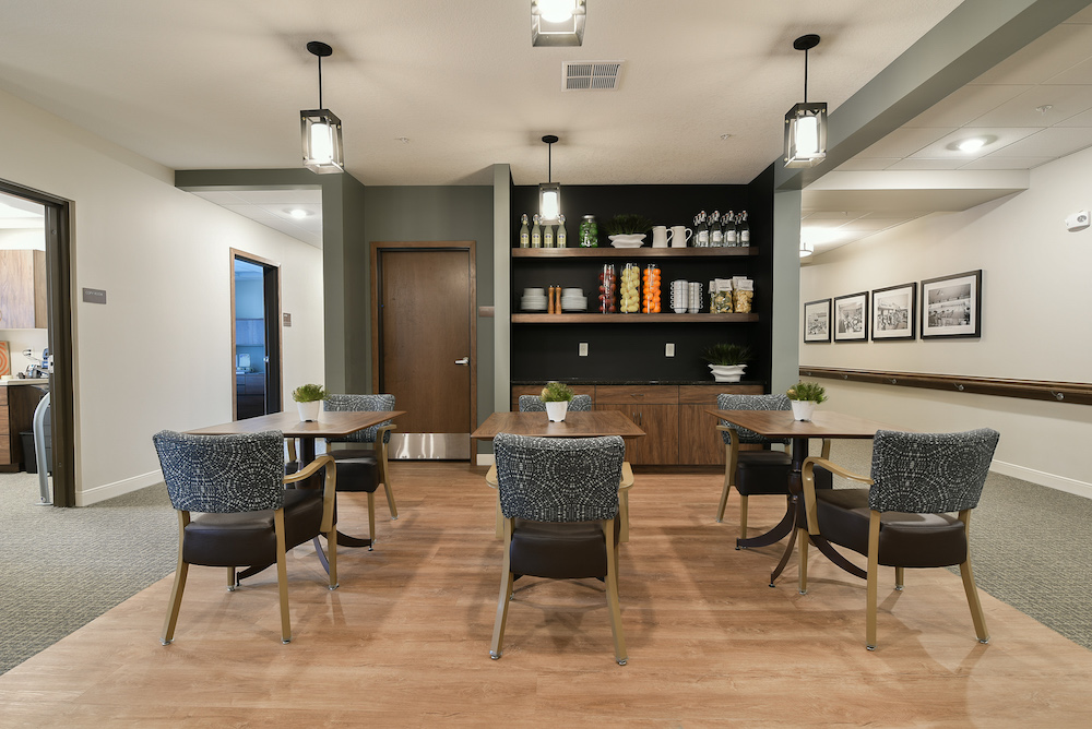 Cozy dining area with modern furniture and shelves filled with decor and pantry items.