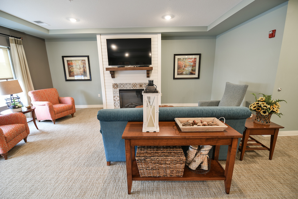 Cozy living room with modern fireplace, flat-screen TV, and comfortable seating arrangements.
