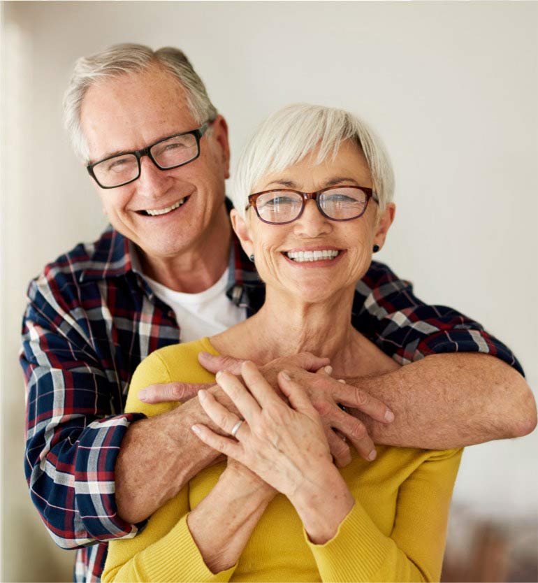 senior-couple Elderly couple smiling with glasses in an affectionate embrace.