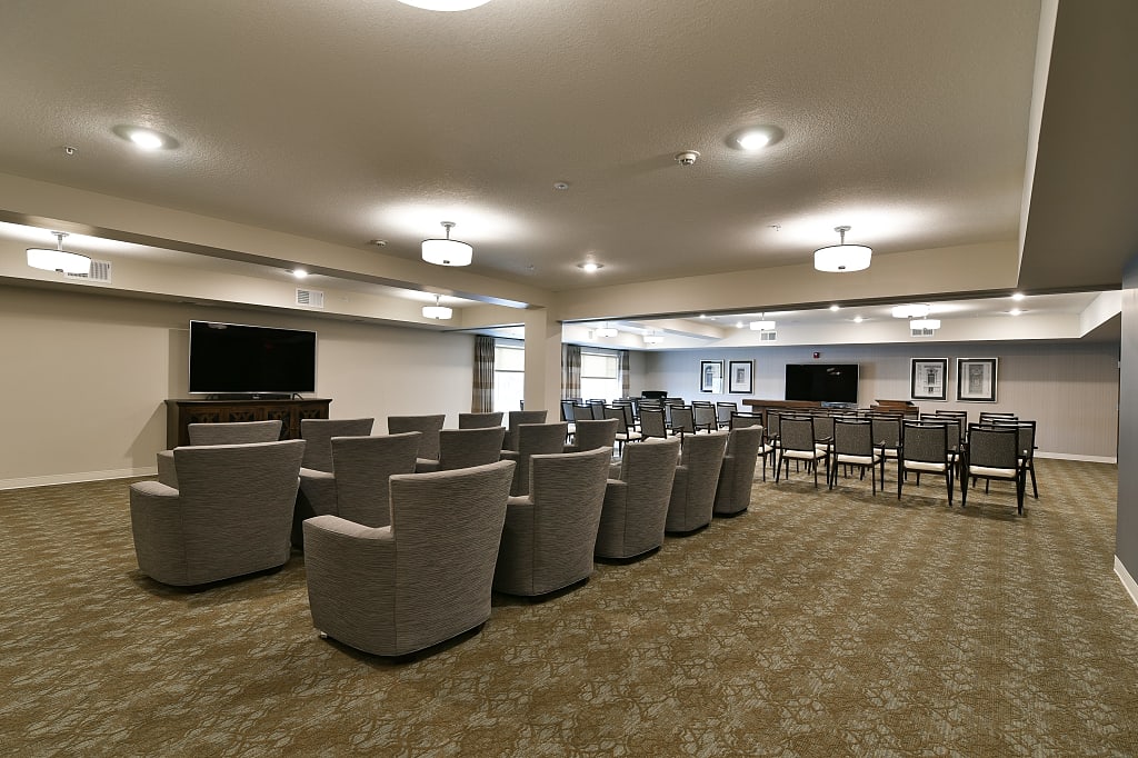 Large meeting room with armchairs and rows of seating.