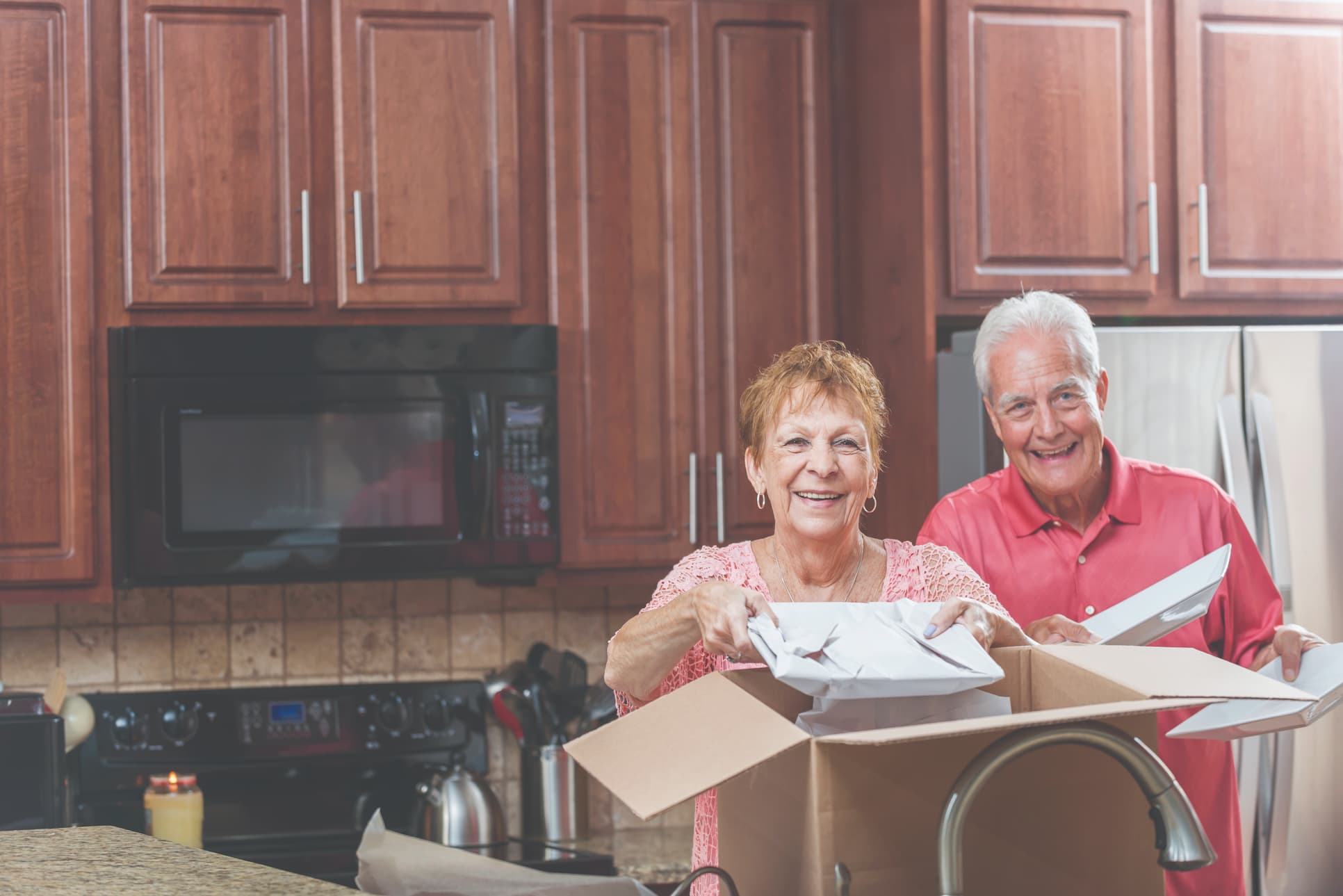 HARI-DownsizingEventImage_2026 Happy senior couple moving boxes